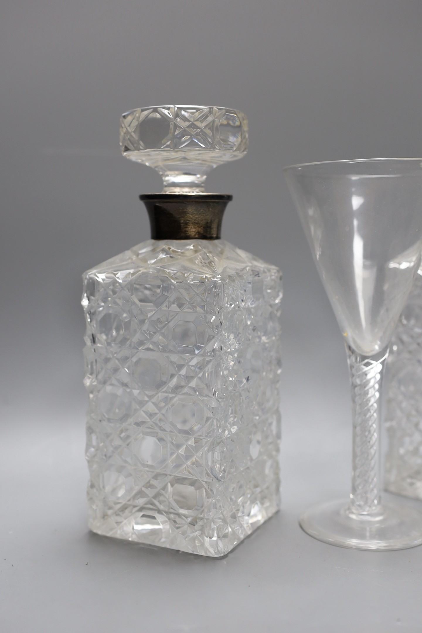 A pair of silver mounted cut glass decanters and stoppers and an air twist stemmed goblet, decanters 24 cms high